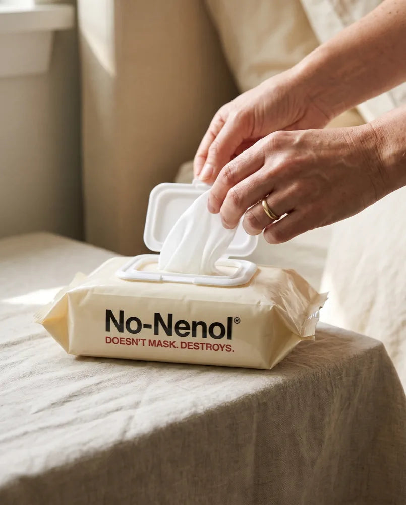 Hands drawing a wipe from a No-Nenol No-Rinse Cleansing Wipes pack